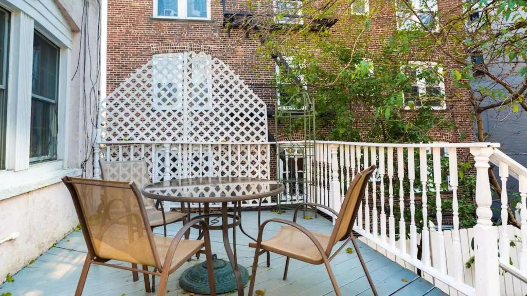 a patio with a table and chairs on a balcony at Skyline 3 BR 20 mins 2 TIME SQ #6 in West New York