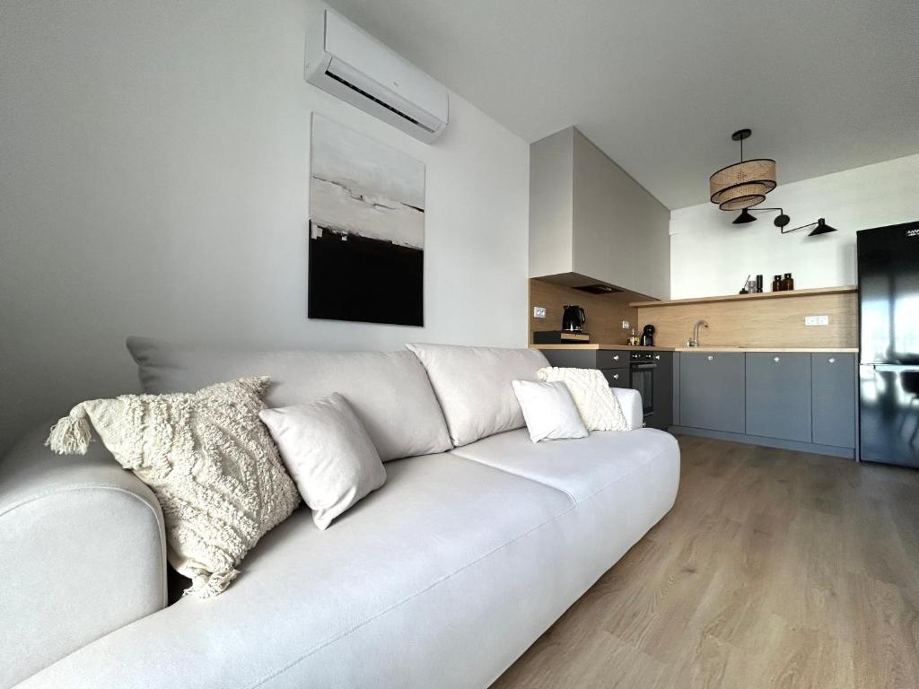 a white couch in a living room with a kitchen at Apartament Lina Koralowa in Lublin