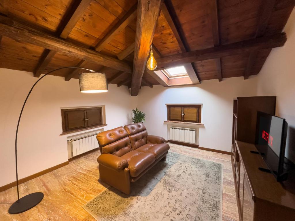- un salon avec un canapé en cuir et une télévision dans l'établissement Suite Carlo - Modena, à Casinalbo