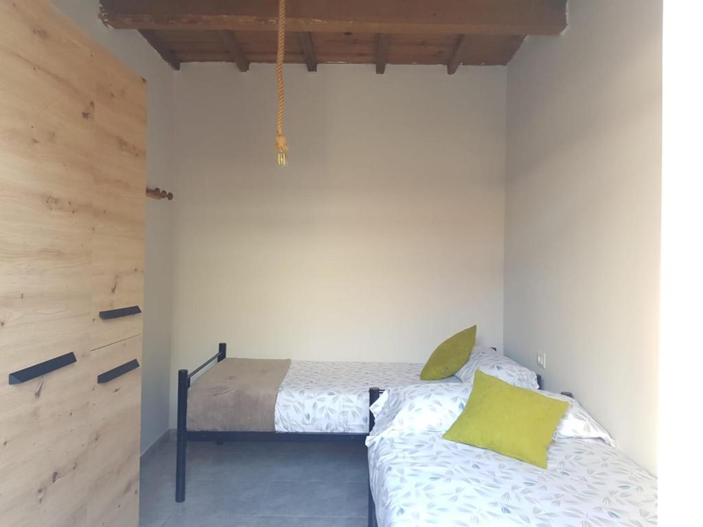 una camera da letto con letto e cuscini gialli di Casa La Porriñesa a Porriño