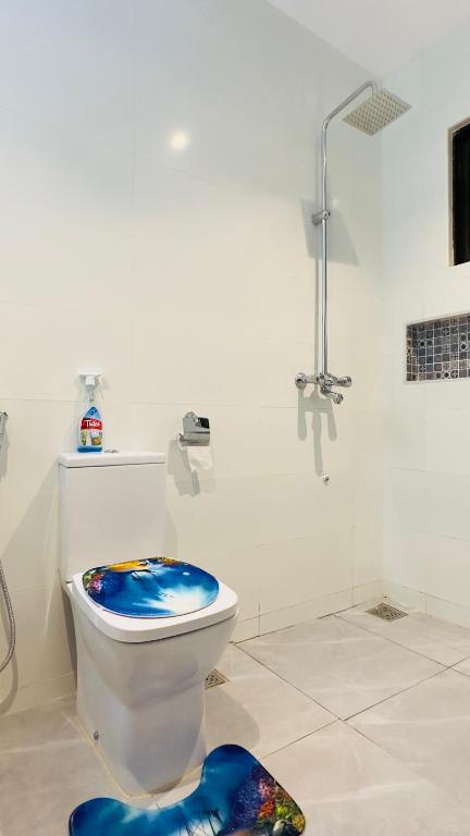 a bathroom with a toilet with a blue seat at The pontoons in Mombasa
