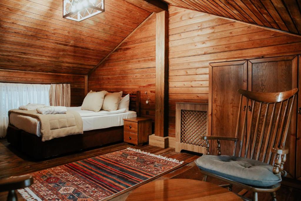 1 dormitorio con 1 cama en una cabaña de madera en Karinna Orman Koskleri, en Uludag