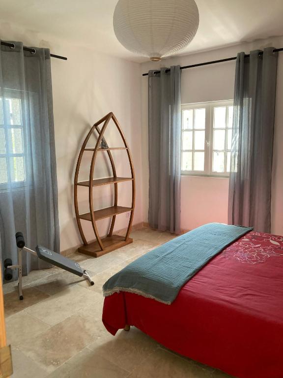um quarto com uma cama vermelha num quarto com janelas em Chambres indépendantes en plein centre historique em Beaucaire