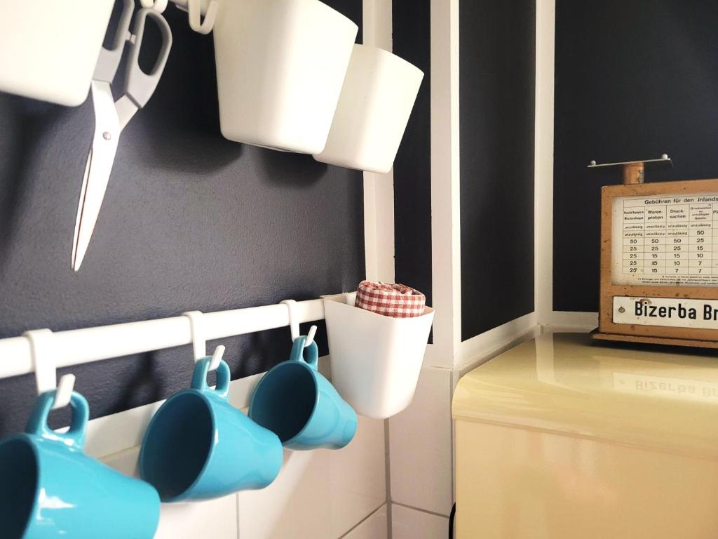 a kitchen with blue mugs hanging on a wall at Get-your-flat - traumhaft niedliche FeWo 2 Zr Kü Bad, Haustier auf Anfrage, ruhig & stadtnah EG - TOP in Bochum