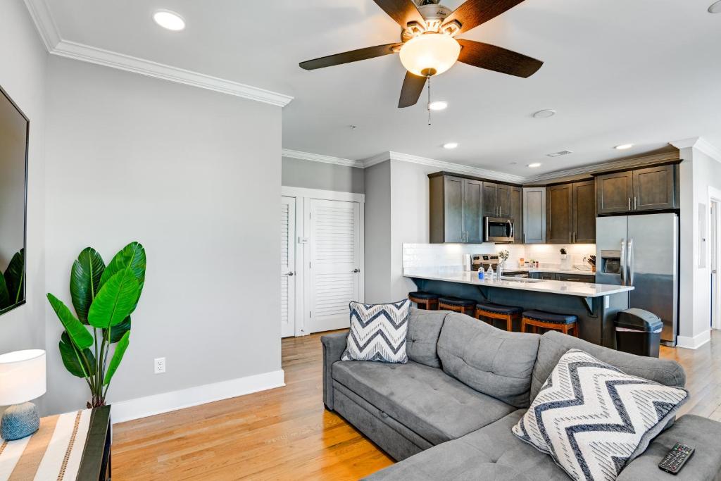 a living room with a couch and a ceiling fan at Modern Nashville Condo Walk to Local Breweries! in Nashville