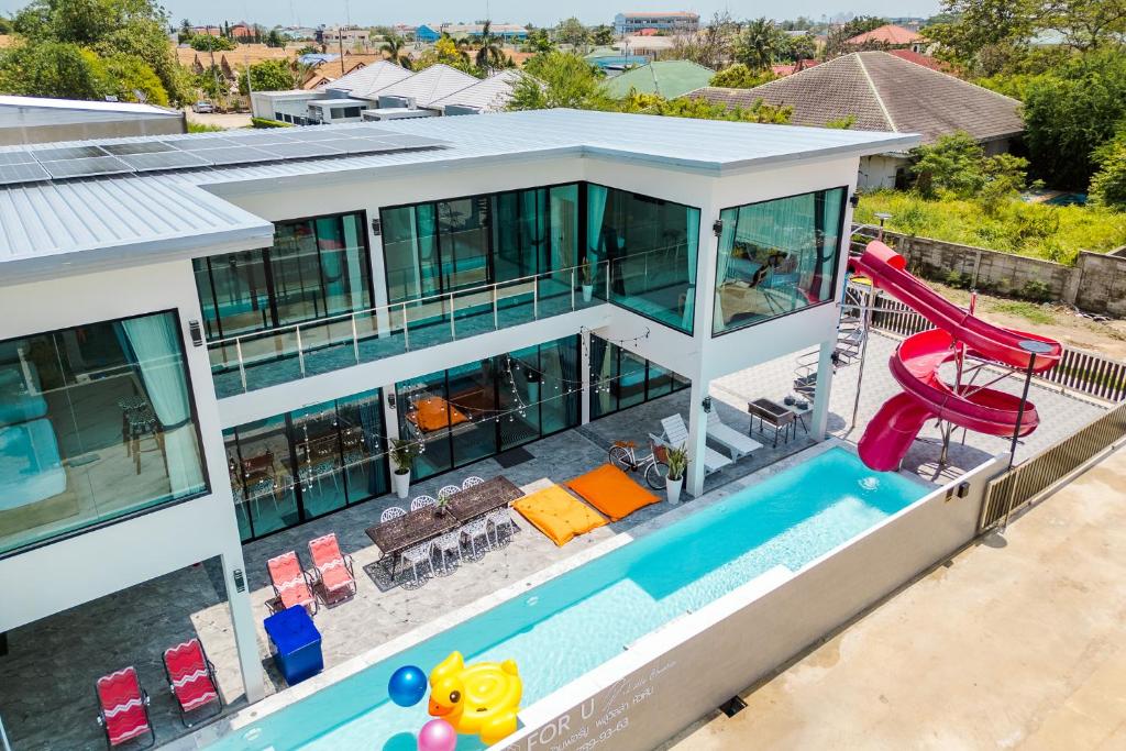 ホアヒンにあるFor U Poolvilla Huahin วิลล่าหลังใหญ่ใกล้เมืองใกล้ทะเลのプールと滑り台付きの家の空中ビュー