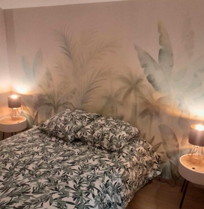 - une chambre avec un lit orné d'une fresque murale de palmiers dans l'établissement Apartment calme, à Remiremont