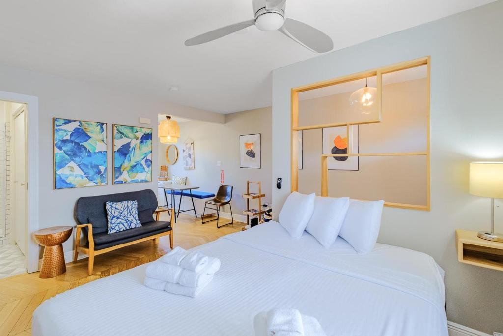 - une chambre avec un grand lit blanc et une chaise dans l'établissement Oak Shores Studio 2, à Biloxi