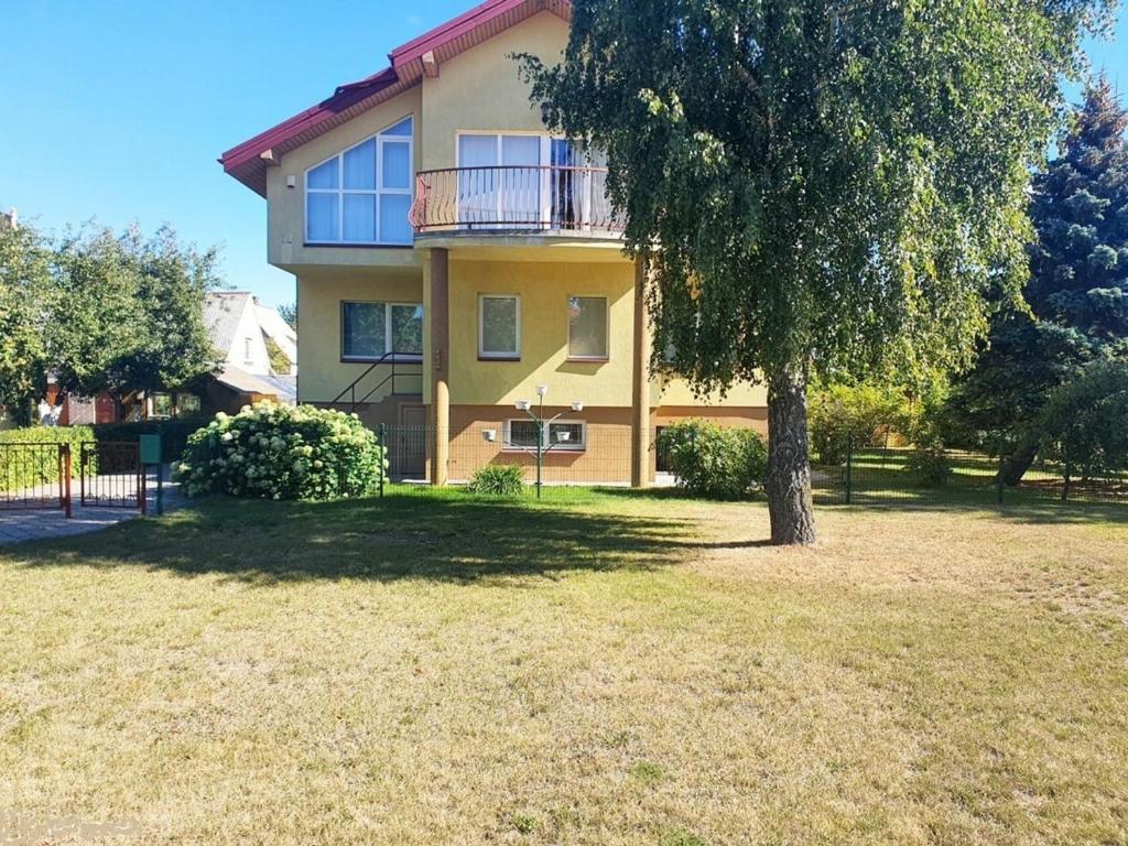 a large house with a tree in front of it at Svečių namai Vilma in Šventoji
