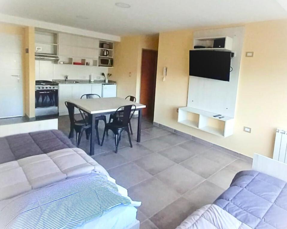 1 dormitorio con cama, mesa y cocina en Tiny Home Ushuaia - Hermoso depto céntrico 1 hab en Ushuaia