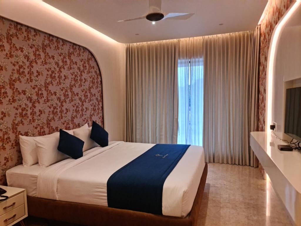 a hotel room with a bed and a television at Luxury Hotel Tumkur in Tumkūr