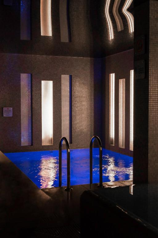 オポーレにあるHotel Wenedaの建物内の青い水の大きなプール