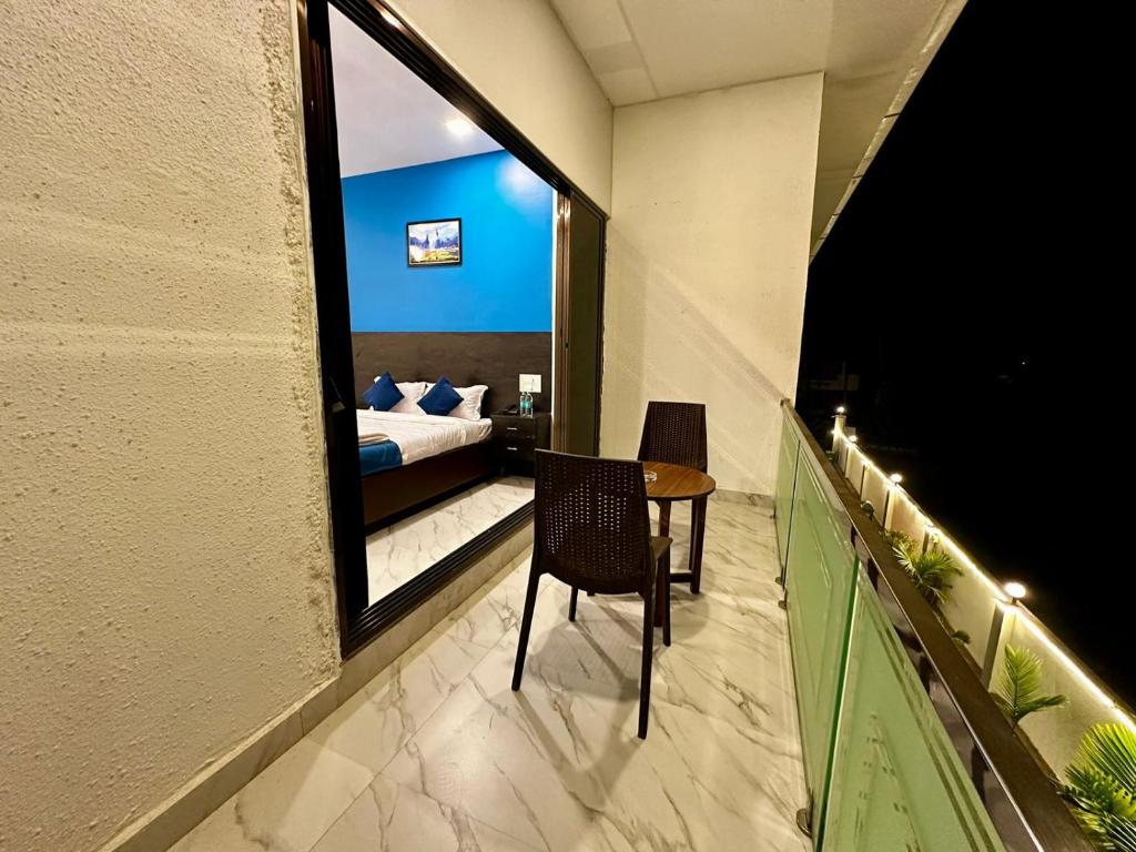 a balcony with a bed and a table and a bedroom at Golden Pearl Resort By Gemstone Hospitality in Alibag