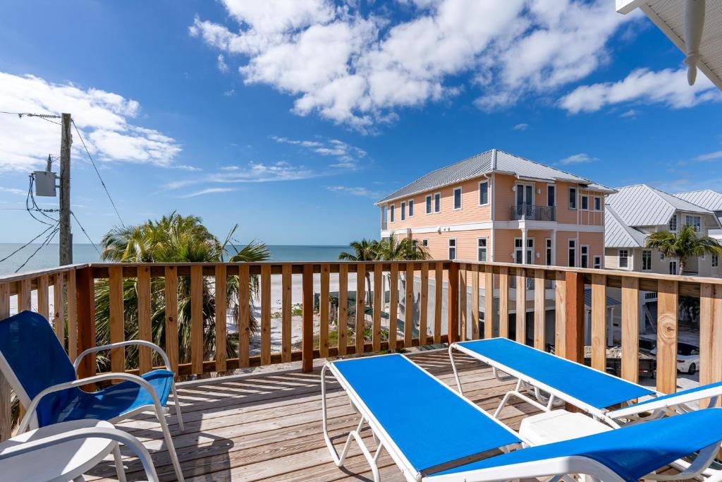a deck with chairs and a table and a building at Castaway Cottage in Fort Myers Beach