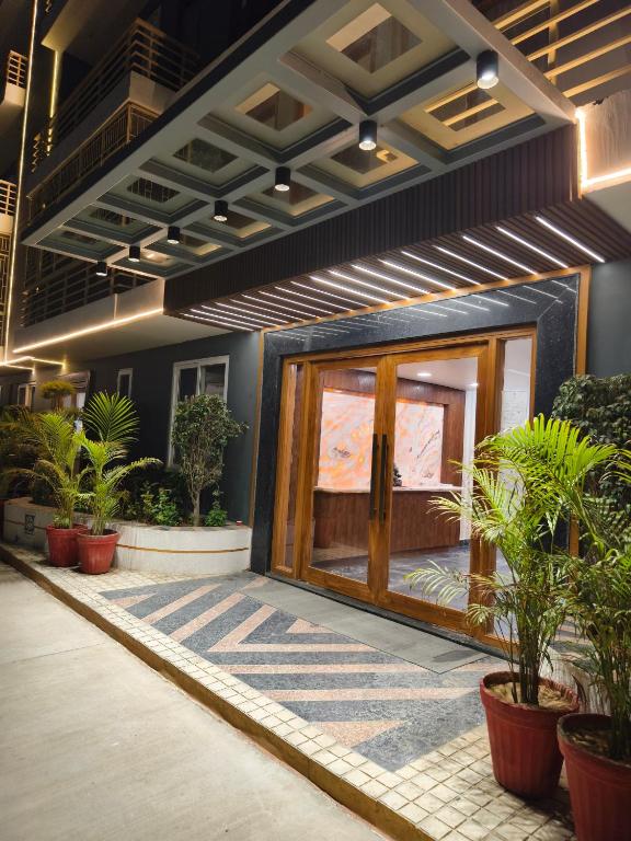 a front door of a building with potted plants at The Grand ND Resort- Kanha Tulsi Heights Behind Prem Mandir in Vrindāvan