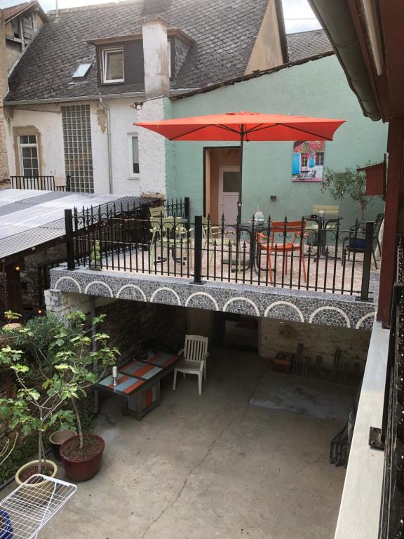 d'une terrasse avec une table et un parasol rouge. dans l'établissement Excellent house, à Ediger-Eller