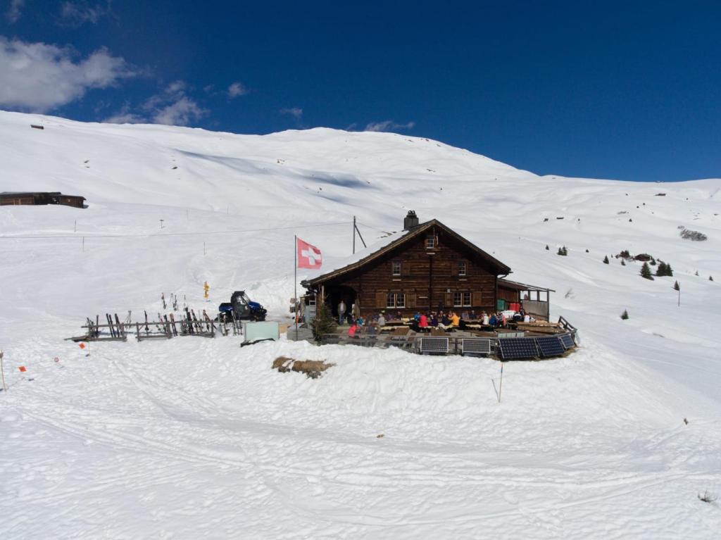une cabane en rondins sur une montagne enneigée dans l'établissement Skihaus Hochwang, à Arosa