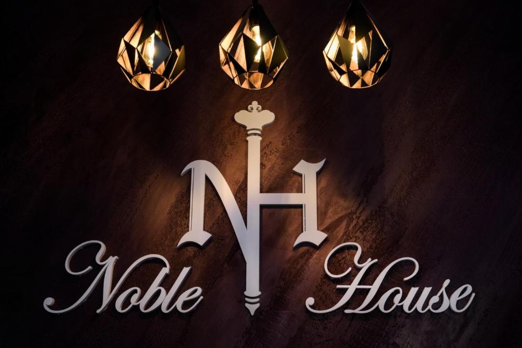 um sinal para uma casa com uma vela e luzes em Noble House em Kriva Palanka