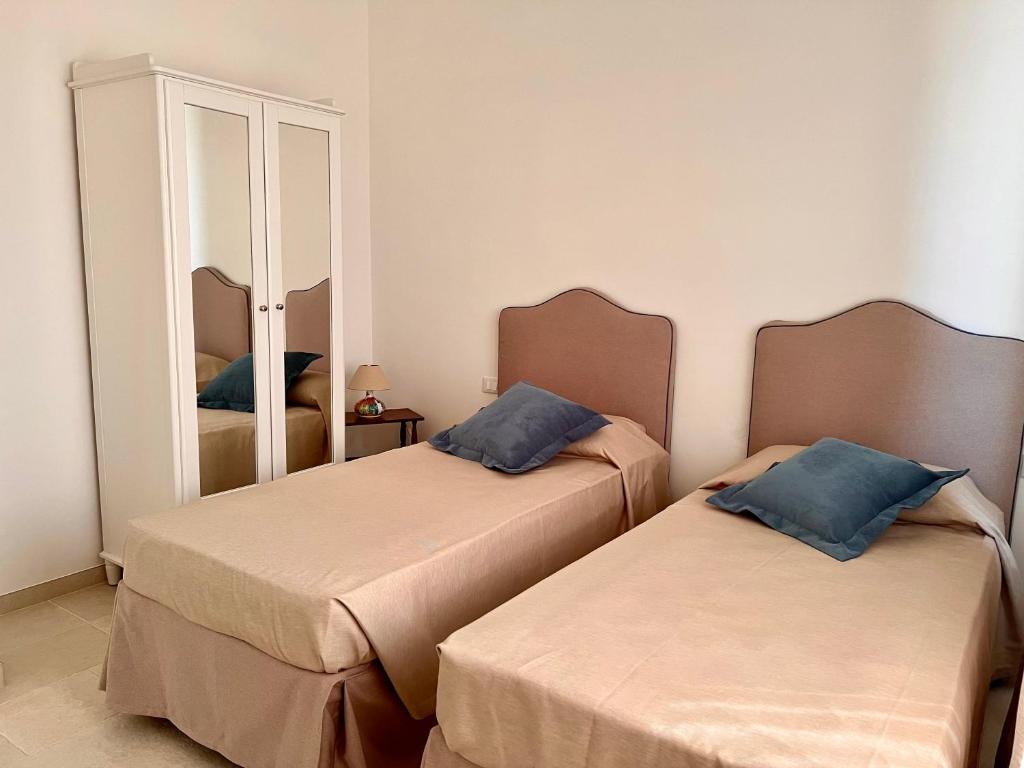 two beds in a room with a mirror at Villa Afrodite in San Pietro in Bevagna