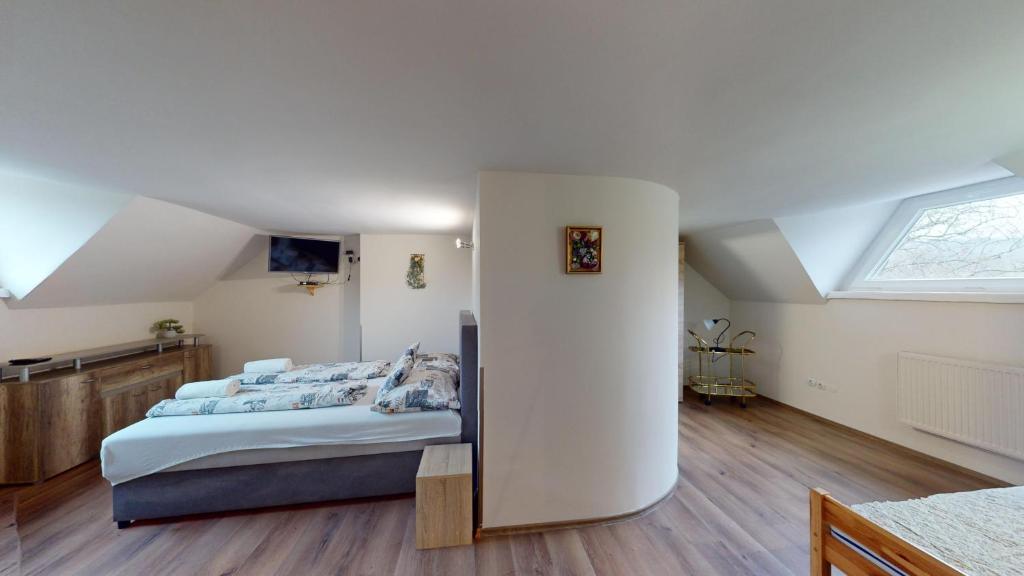 sypialnia z dużym łóżkiem na poddaszu w obiekcie Herczeg Apartment w Miskolc-Tapolca