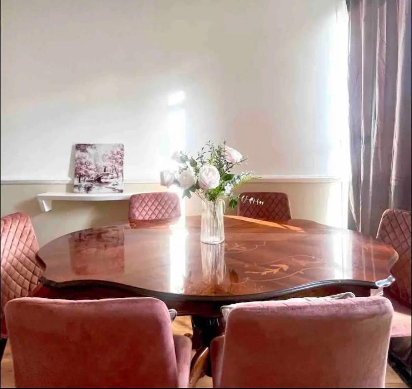 uma mesa de jantar com cadeiras e um vaso de flores em Holiday apartment Central London em Londres