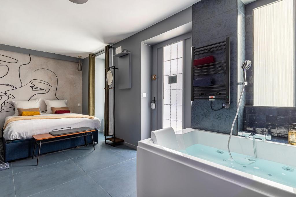 1 dormitorio con cama y bañera en Opéra, Grand Boulevard 9ème, suite avec jacuzzi, en París