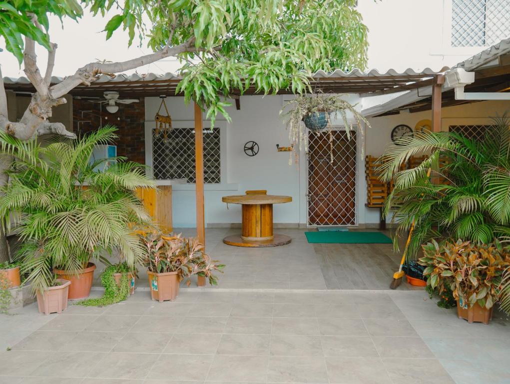 a patio with a table and some trees and plants at Casa al pie de la playa con Aire acondicionado y BBQ in Playas