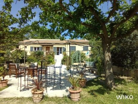 d'une terrasse avec des chaises et une table dans la cour. dans l'établissement A L'Orée du Bois, à Baron