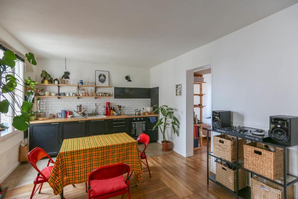 uma cozinha com mesa e cadeiras num quarto em Bright apartment in Aubervilliers em Aubervilliers