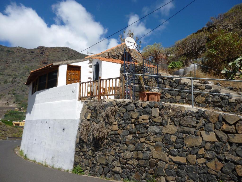 a house with a stone wall next to a street at Casa Luis in Hermigua