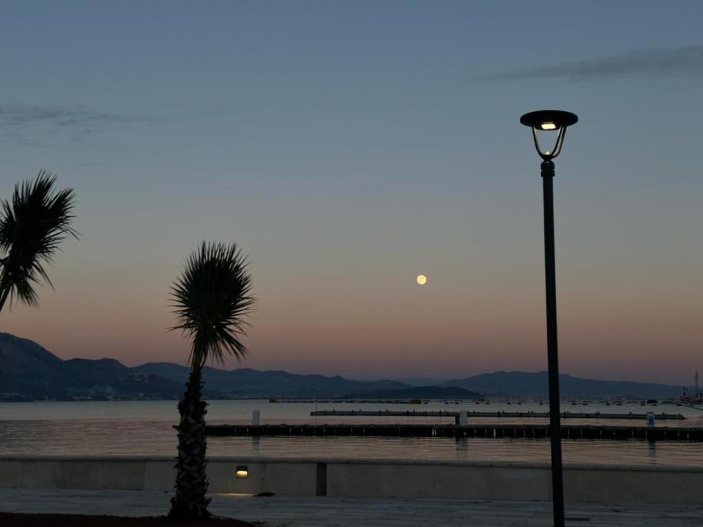a street light and a palm tree on a beach at MareLuna in Gaeta