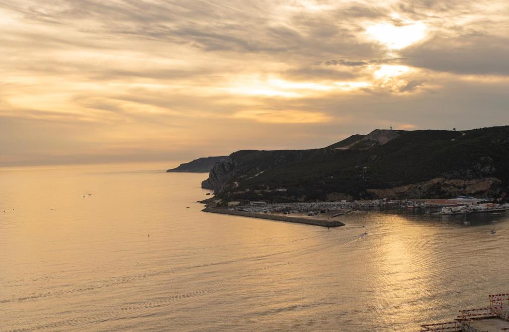 a view of a body of water with a hill at To see the sea apartment in Sesimbra