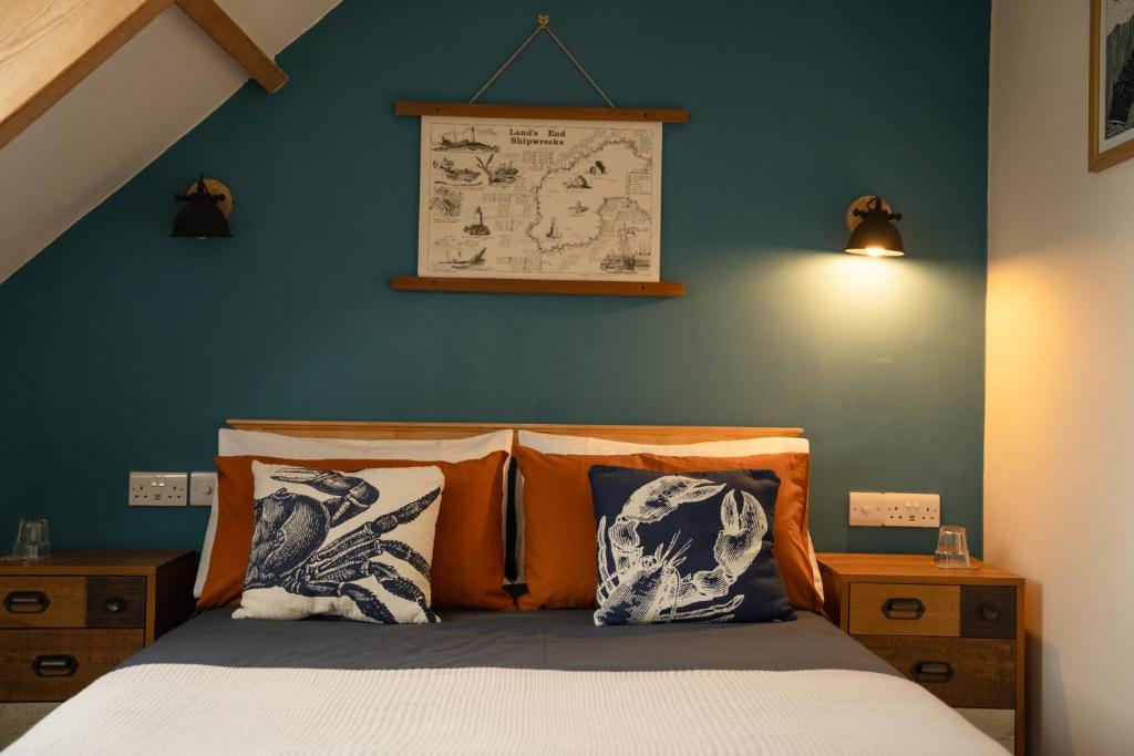 a bedroom with a bed with a blue wall at EasyPZ Stay in Penzance