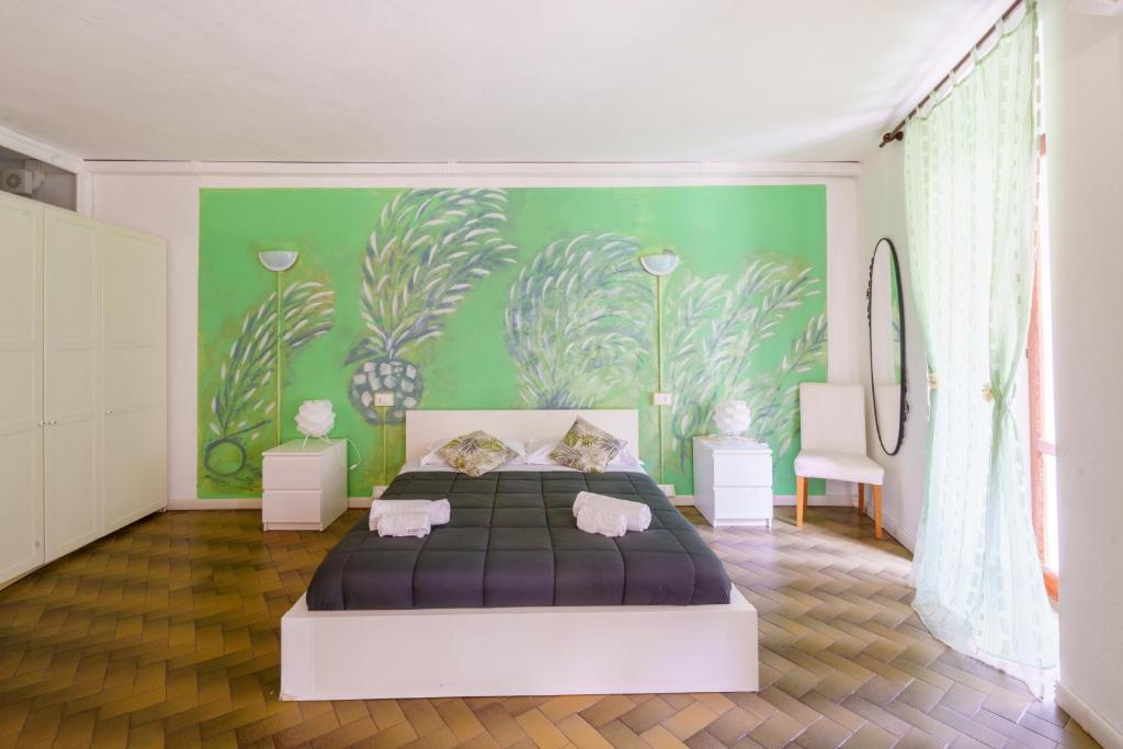 een slaapkamer met een bed en een groene muur bij Lory's Suite in Manarola