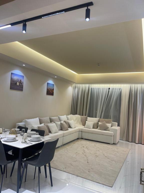 un soggiorno con divano bianco e tavolo di شقة فندقية ALzorah Ajman - الزوراء عجمان ad Ajman