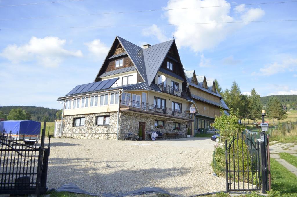 ein großes Haus mit einem Gameradach in der Unterkunft Willa Czerwone Wierchy in Kościelisko