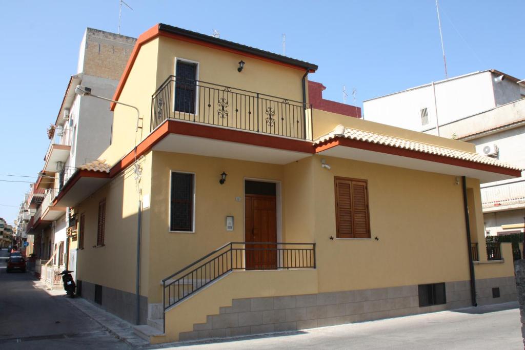 una casa gialla con balcone su una strada di Casa Viola a Pozzallo