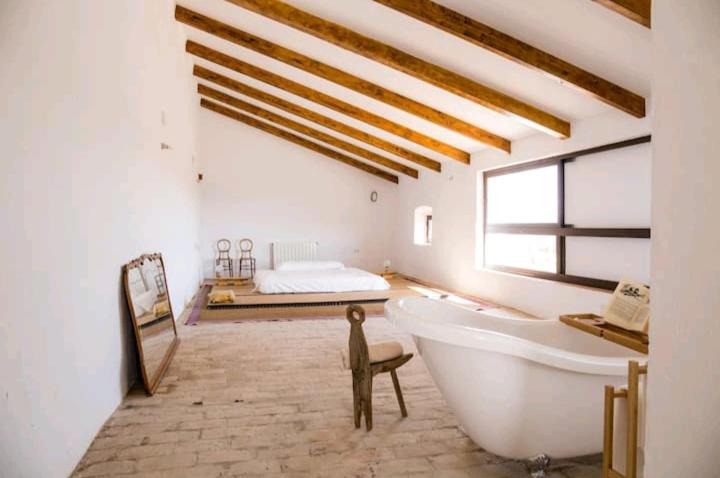 Habitación con baño con bañera y cama. en La Aceitera, en Bollullos de la Mitación
