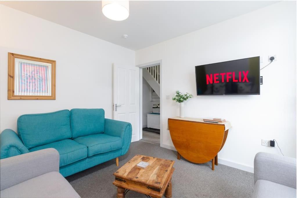a living room with a blue couch and a table at Spacious 4 Bed house W/Free Parking Sleeps 7 Near Walsgrave Hospital in Wyken