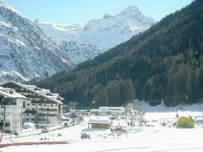 a snow covered city with a mountain in the background at Condominio Colmet in La Thuile