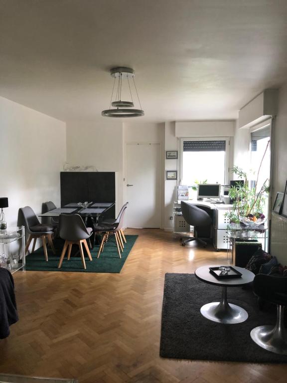 a living room with a dining table and chairs at JO 2024 Bel APPARTEMENT DANS UN ECO QUARTIER ANIME PROCHE METRO TRAM ET TOUR EIFFEL in Boulogne-Billancourt