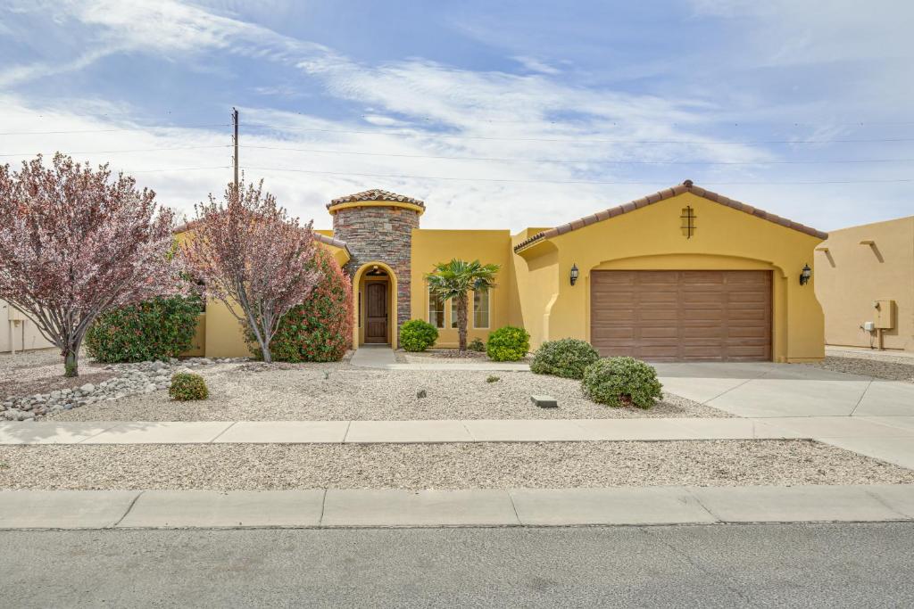 a large yellow house with a garage at Unique Las Cruces Home with Patio and Gas Grill! in Las Cruces