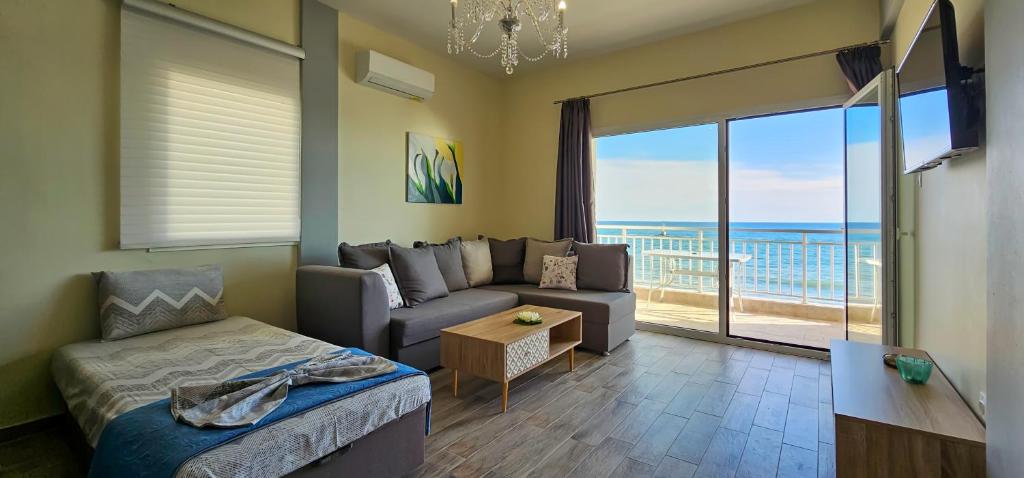 a living room with a couch and a view of the ocean at HARA APARTMENT In Front Of The Beach in Paralia Katerinis