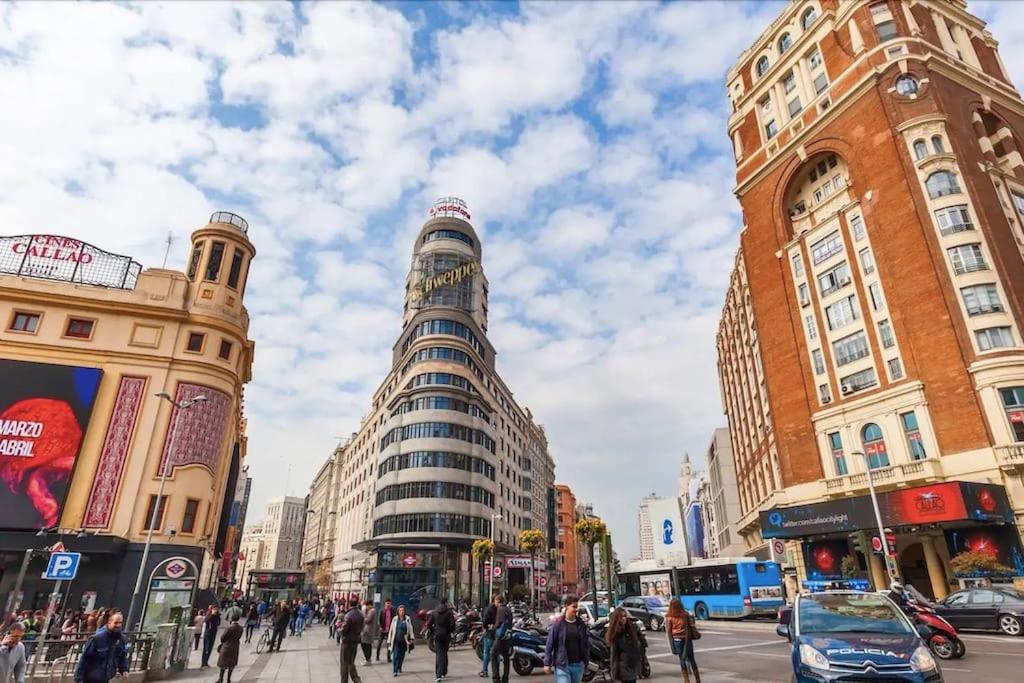 una concurrida calle de la ciudad con edificios altos y peatones en Punta me Apartments in the best location Madrid Downtown en Madrid