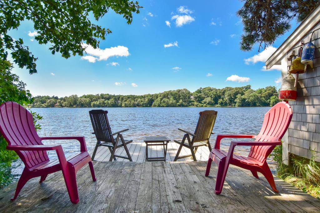 quattro sedie sedute su un molo vicino all'acqua di 10 ft from Crystal Lake New renovation a Orleans