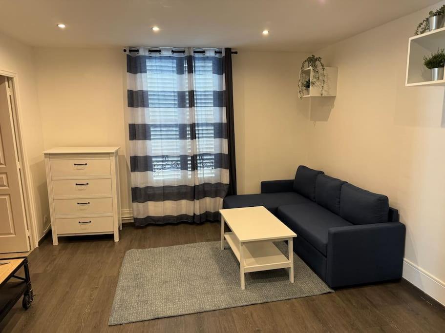 una sala de estar con un sofá y una mesa en Cosi apartment near La Défense, en Courbevoie