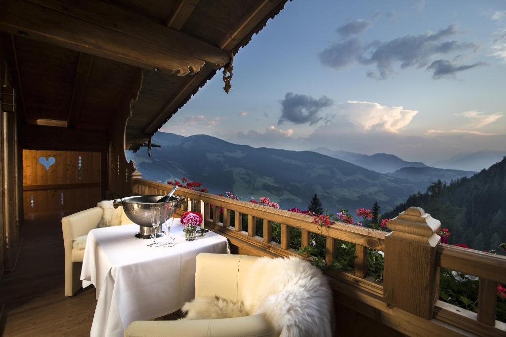 a balcony with a table and chairs with a view of mountains at Luxus Chalet Bischofer- Bergwelt in Alpbach