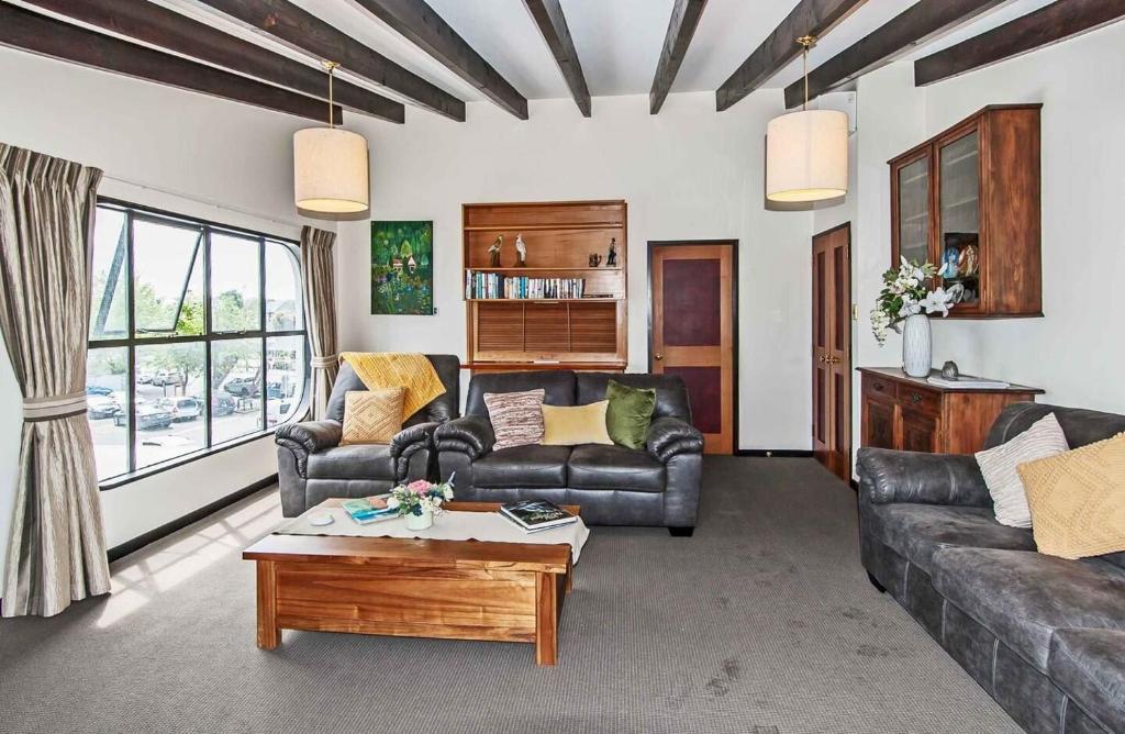 a living room with couches and a coffee table at Prime Location Handy CBD& Restaurants in Christchurch