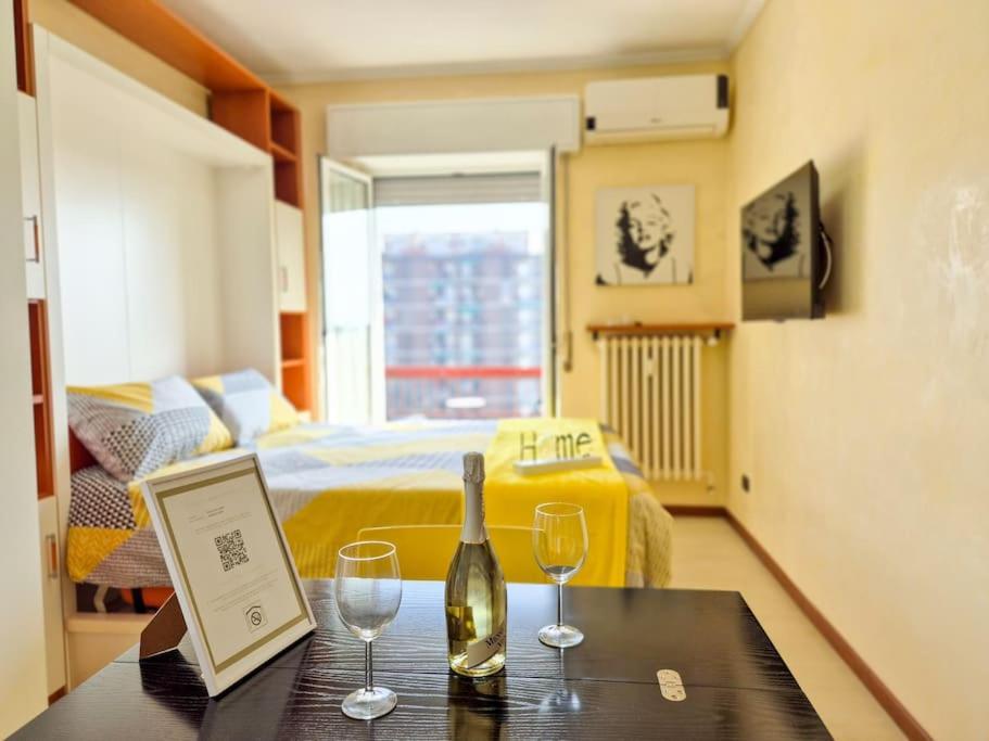 a room with a bed and a table with wine glasses at Milano/Cinisello Tram 31 (M5 BIGNAMI) in Cinisello Balsamo