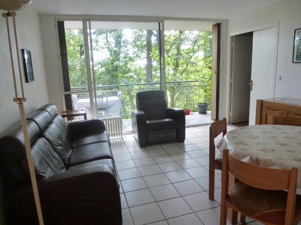 ein Wohnzimmer mit einem Sofa und einem Tisch in der Unterkunft Spacious Condo, Green Serenity in Palaiseau